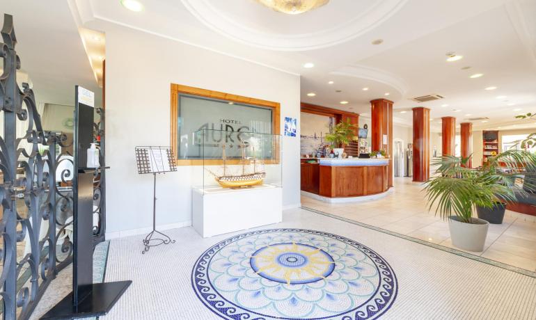 Elegante Hotellobby, buntes Mosaik und Schiffsmodell.